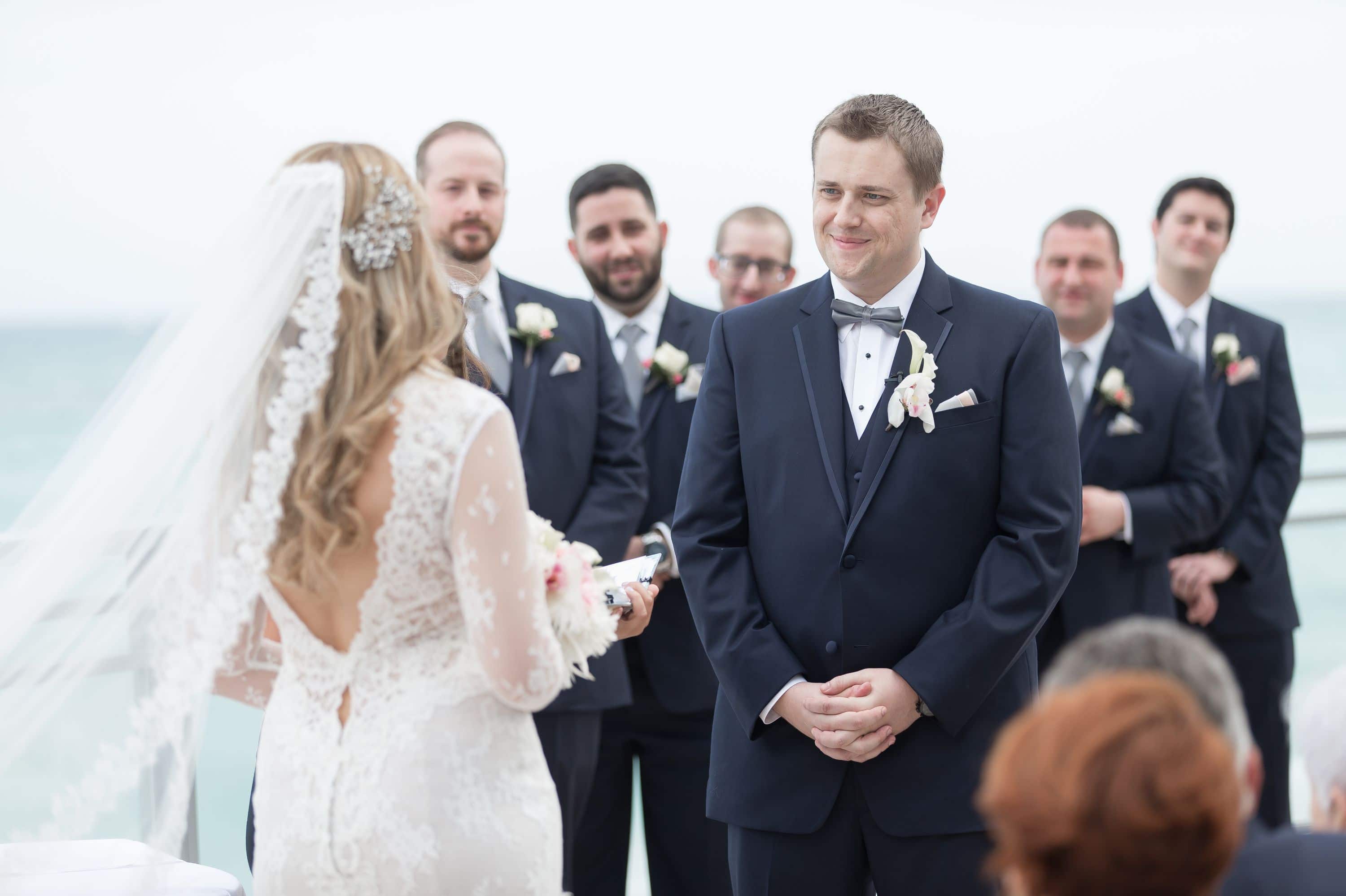 Candid shot of the groom during the ceremony at this Diplomat Beach Resort Wedding
