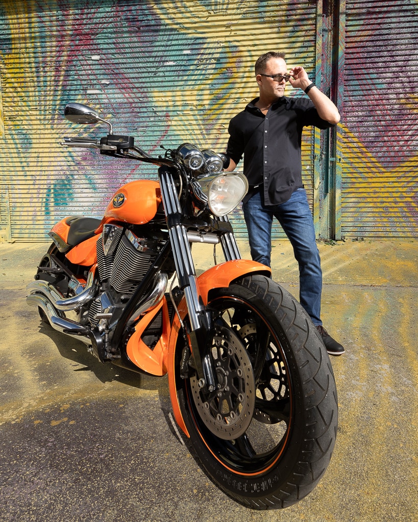 Groom posing with his motorcycle in the Design District of Miami on engagement session